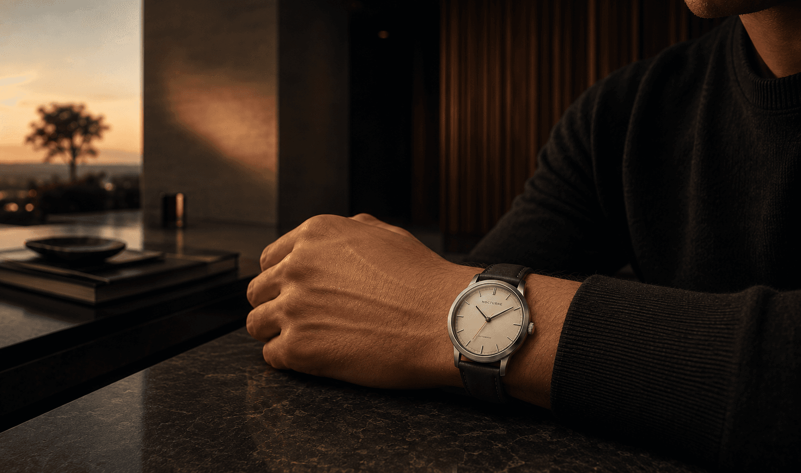 A NOCTURNE Atria worn beside a timber desk in warm architectural evening light